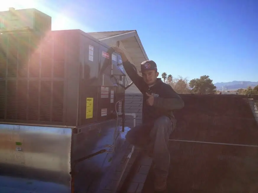 HVAC technician performing AC Tune-Up on a rooftop unit in High Springs